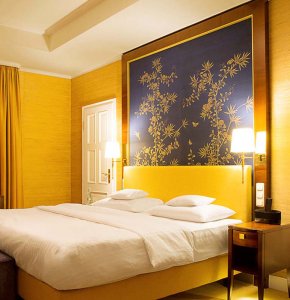 kempiski hotel bedroom with silk chinoiserie wallpaper gold bamboo garden